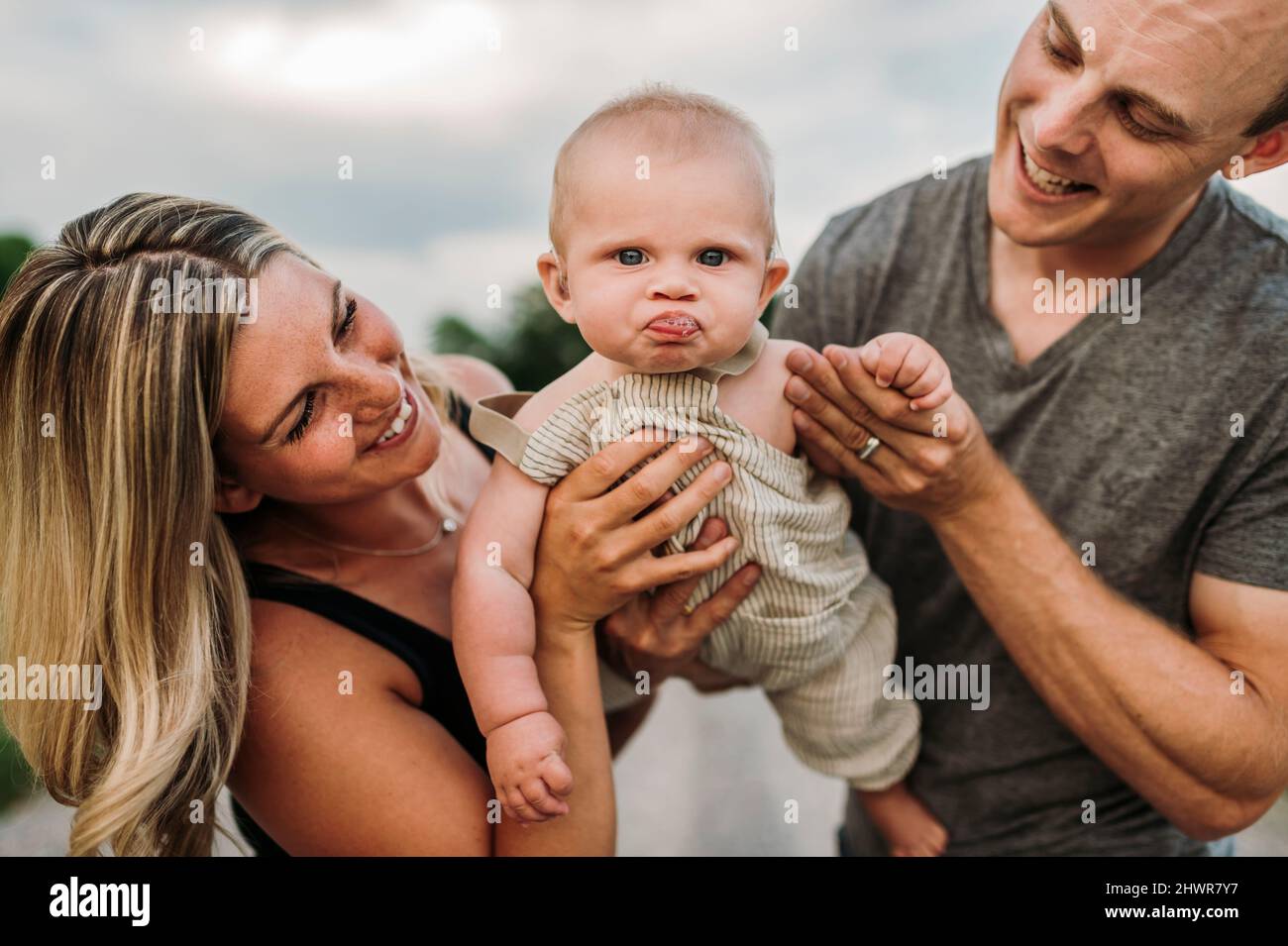 I genitori felici con il figlio cute del bambino che fa la faccia divertente Foto Stock