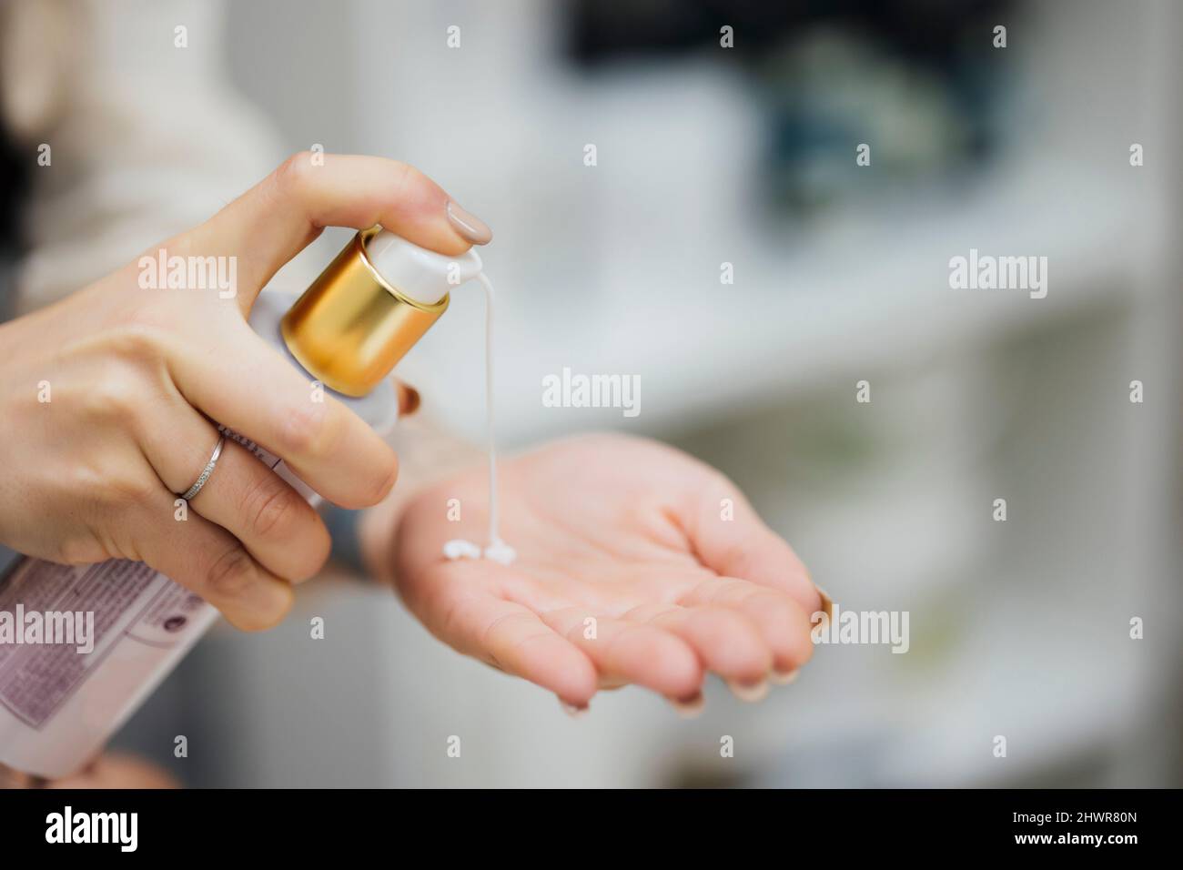 Mani di donna che applicano moisturizer Foto Stock