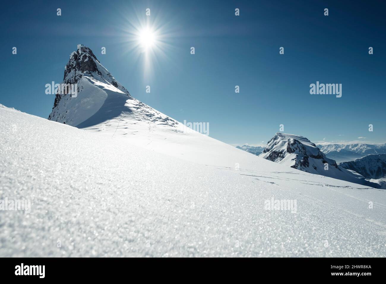 Sole che brilla sulla vetta innevata delle montagne Rofan Foto Stock