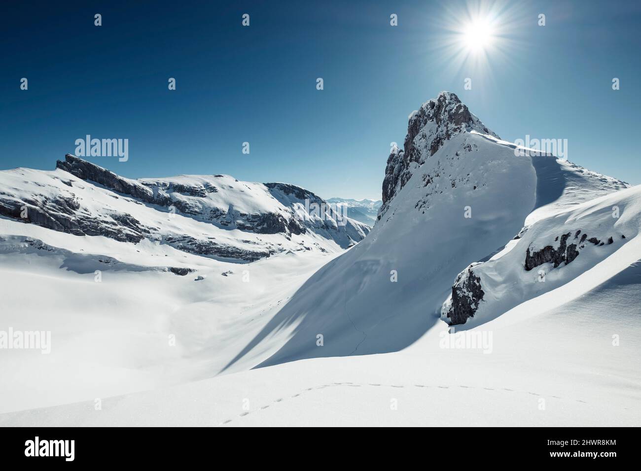 Il sole splende sulle piste degli animali nelle montagne innevate di Rofan Foto Stock
