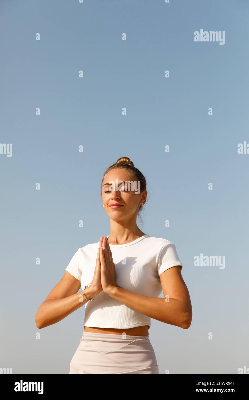 Donna in una posa di meditazione sulla spiaggia Foto Stock