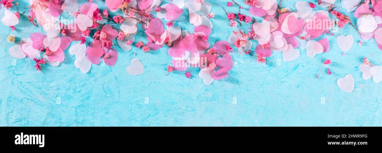Panorama di San Valentino o di nozze con cuori rosa e fiori di confetti, un'intestazione panoramica piatta su sfondo blu con spazio copia Foto Stock