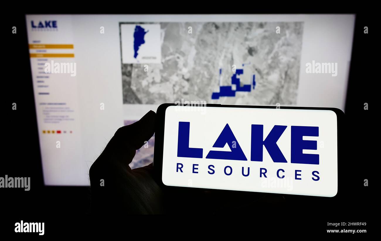 Persona che tiene uno smartphone con il logo della compagnia australiana di litio Lake Resources N.L. sullo schermo di fronte al sito web. Mettere a fuoco sul display del telefono. Foto Stock