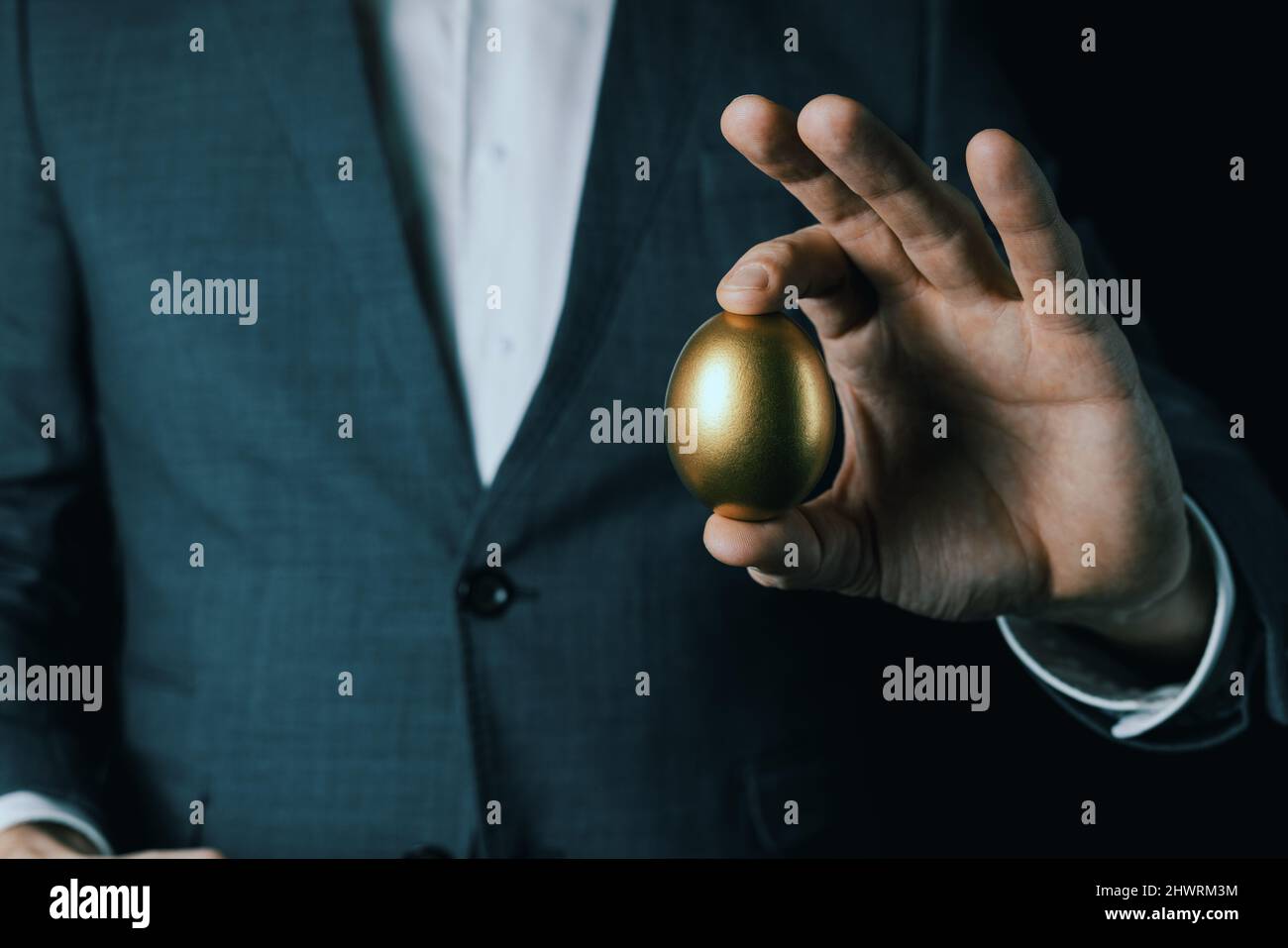 uovo d'oro in mano d'uomo d'affari. concetto di successo, profitto, o ricchezza Foto Stock