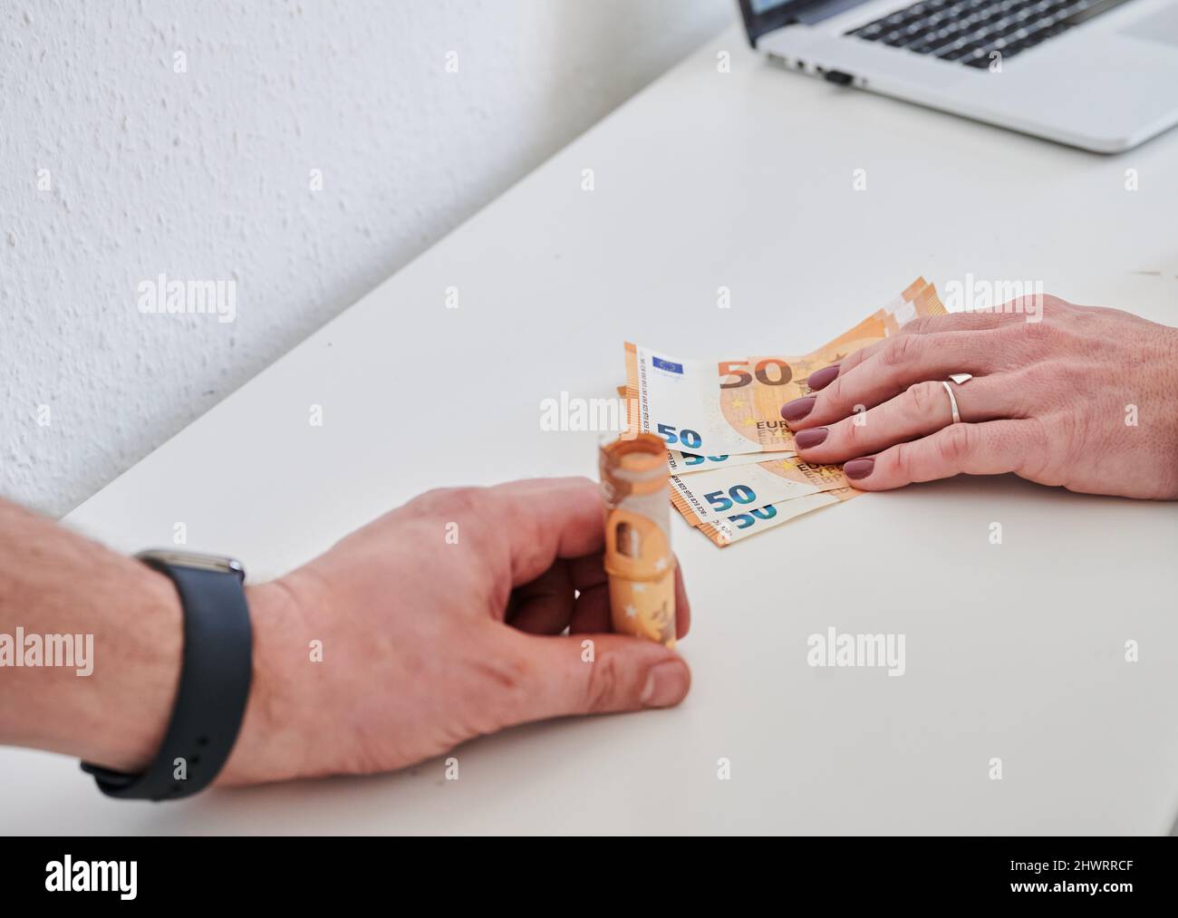 Berlino, Germania. 05th Mar 2022. La mano di un uomo (l) contiene un pacchetto di bollette da 50 euro, mentre la mano di una donna tiene solo poche bollette da 50 euro. Le donne in Germania hanno continuato a guadagnare in media meno degli uomini nel 2021. Il divario di reddito, il cosiddetto divario retributivo di genere, è rimasto invariato rispetto all'anno precedente, attestandosi al 18%. Tale calcolo è stato effettuato dall'Ufficio federale di statistica. Credit: Annette Riedl/dpa/Alamy Live News Foto Stock