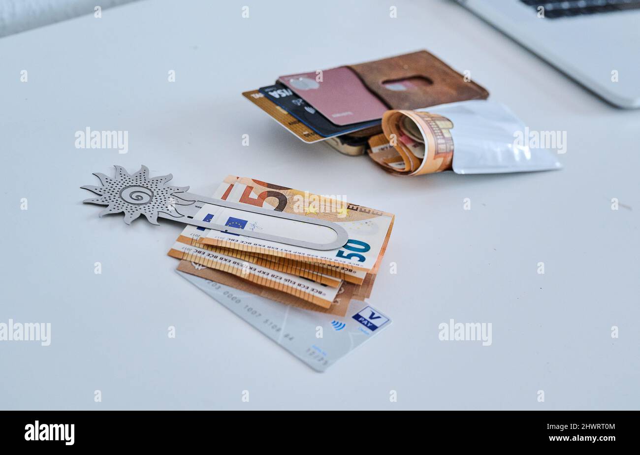 Berlino, Germania. 05th Mar 2022. Una clip di denaro femminile con bollette da 50 euro e una carta conto corrente si trova accanto a un astuccio in pelle con diverse carte di credito e un pacchetto di bollette da 50 euro. Le donne in Germania hanno continuato a guadagnare in media meno degli uomini nel 2021. Il divario di reddito, il cosiddetto divario retributivo di genere, è rimasto invariato rispetto all'anno precedente, attestandosi al 18%. Tale calcolo è stato effettuato dall'Ufficio federale di statistica. Credit: Annette Riedl/dpa/Alamy Live News Foto Stock