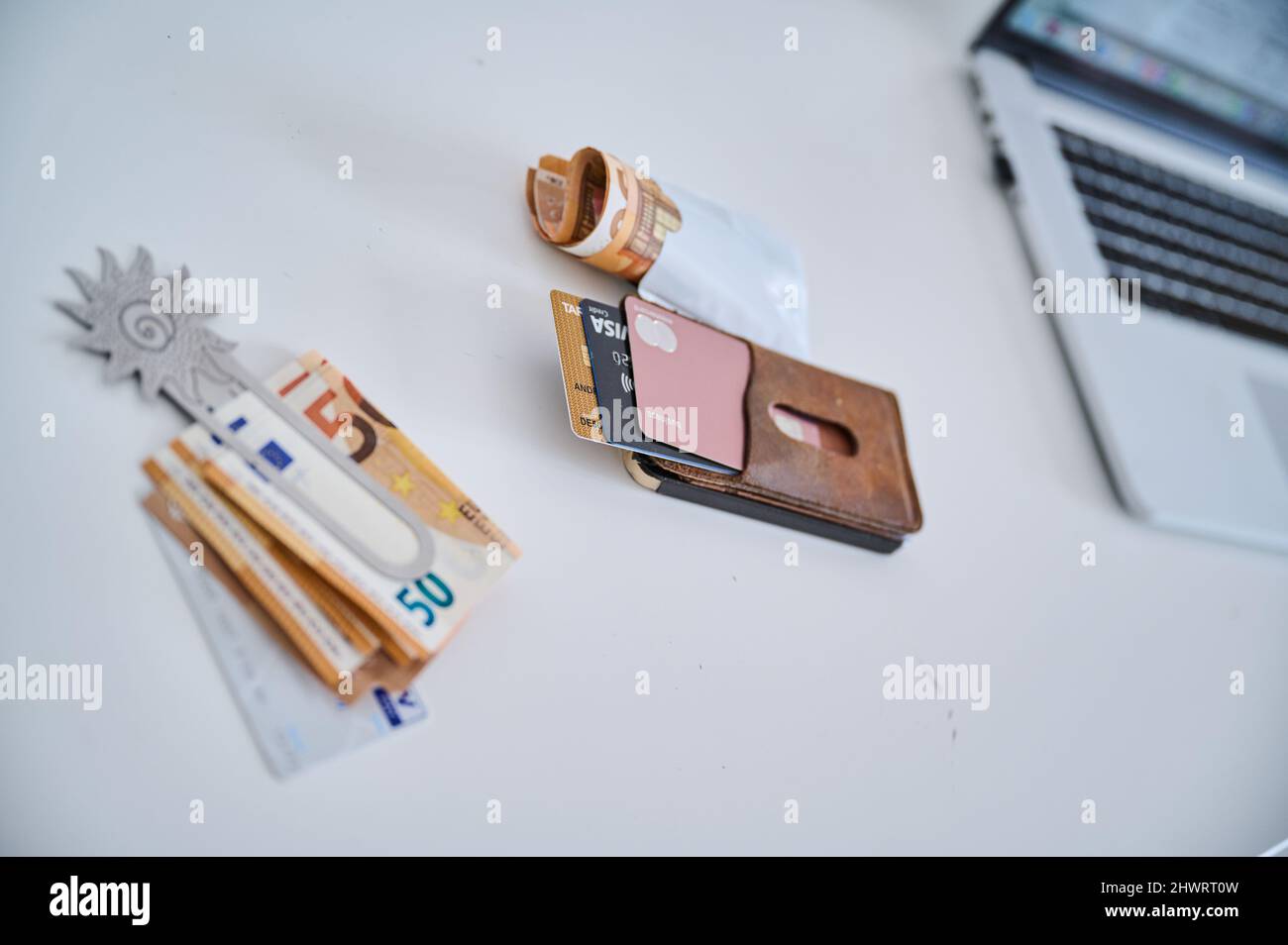 Berlino, Germania. 05th Mar 2022. Una clip di denaro femminile con bollette da 50 euro e una carta conto corrente si trova accanto a un astuccio in pelle con diverse carte di credito e un pacchetto di bollette da 50 euro. Le donne in Germania hanno continuato a guadagnare in media meno degli uomini nel 2021. Il divario di reddito, il cosiddetto divario retributivo di genere, è rimasto invariato rispetto all'anno precedente, attestandosi al 18%. Tale calcolo è stato effettuato dall'Ufficio federale di statistica. Credit: Annette Riedl/dpa/Alamy Live News Foto Stock