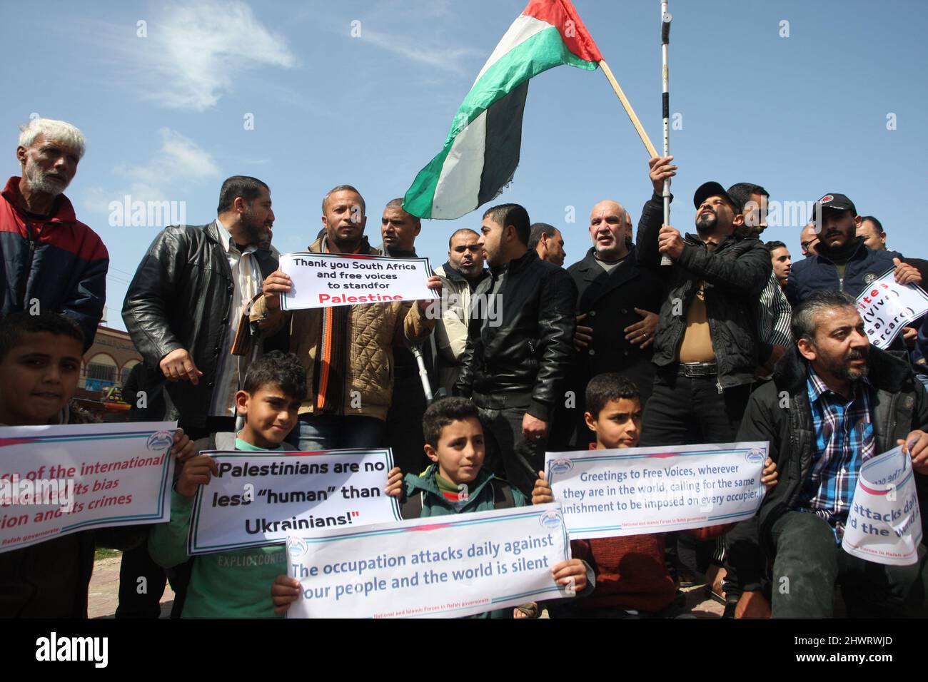 Rafah, Gaza. 07th Mar 2022. I palestinesi sollevano cartelli durante un raduno che chiede il sostegno internazionale ai palestinesi contro Israele al campo profughi di Rafah nella striscia di Gaza lunedì 7 marzo 2022. I cartelli sono simili a quelli mostrati per gli ucraini contro la Russia. Foto di Ismael Mohamad/UPI Credit: UPI/Alamy Live News Foto Stock