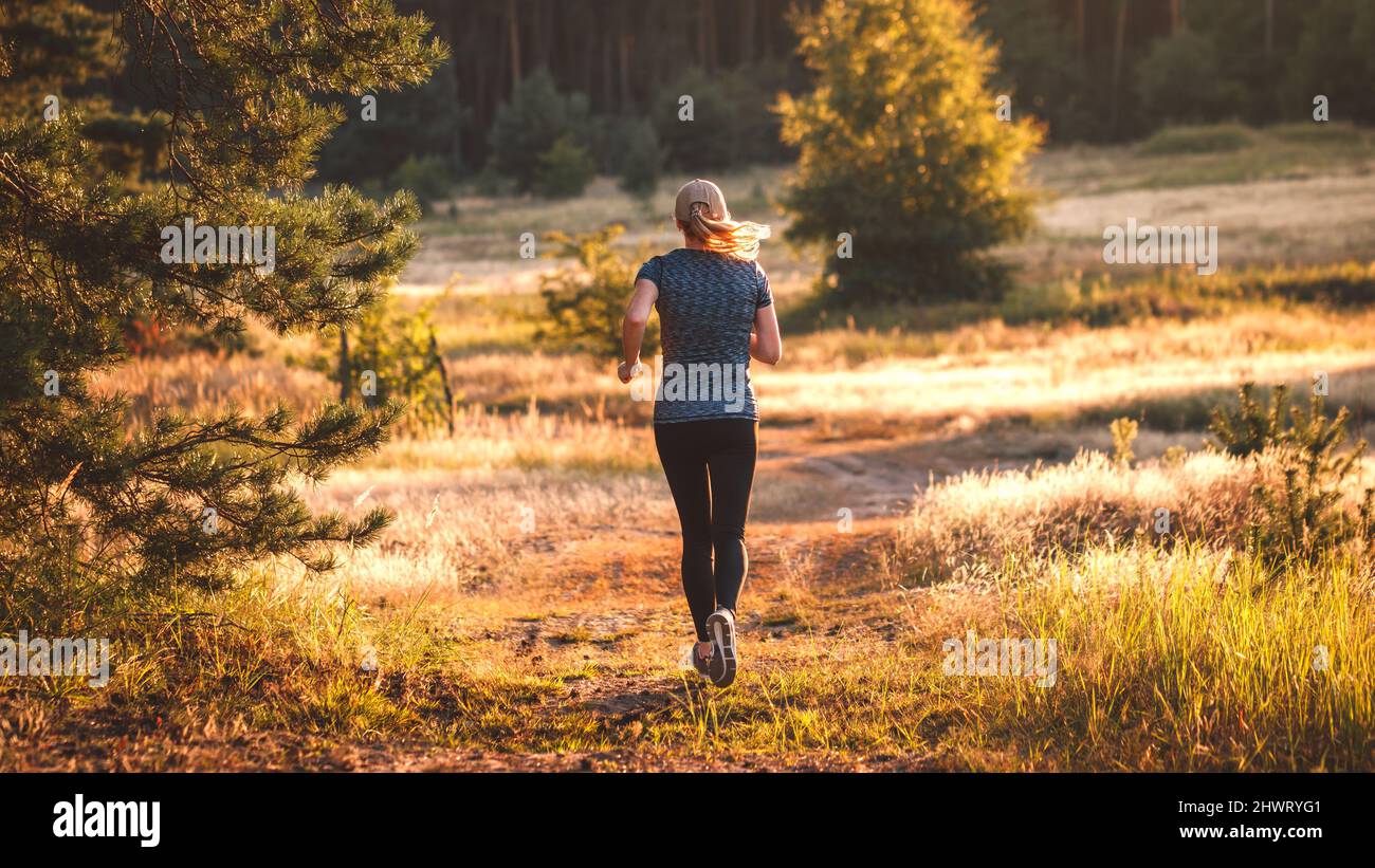 La donna corre in natura. Femmina runner jogging all'aperto. Corsa di fondo. Allenamento sportivo e stile di vita sano e attivo Foto Stock