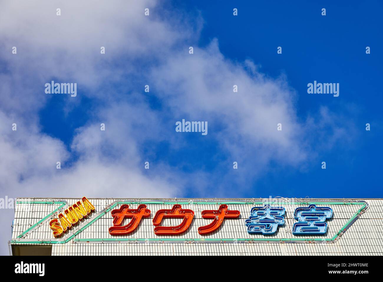 Sauna Yorimiya, segno su parete bianca-piastrellata contro cielo blu; Naha, Okinawa, Giappone Foto Stock