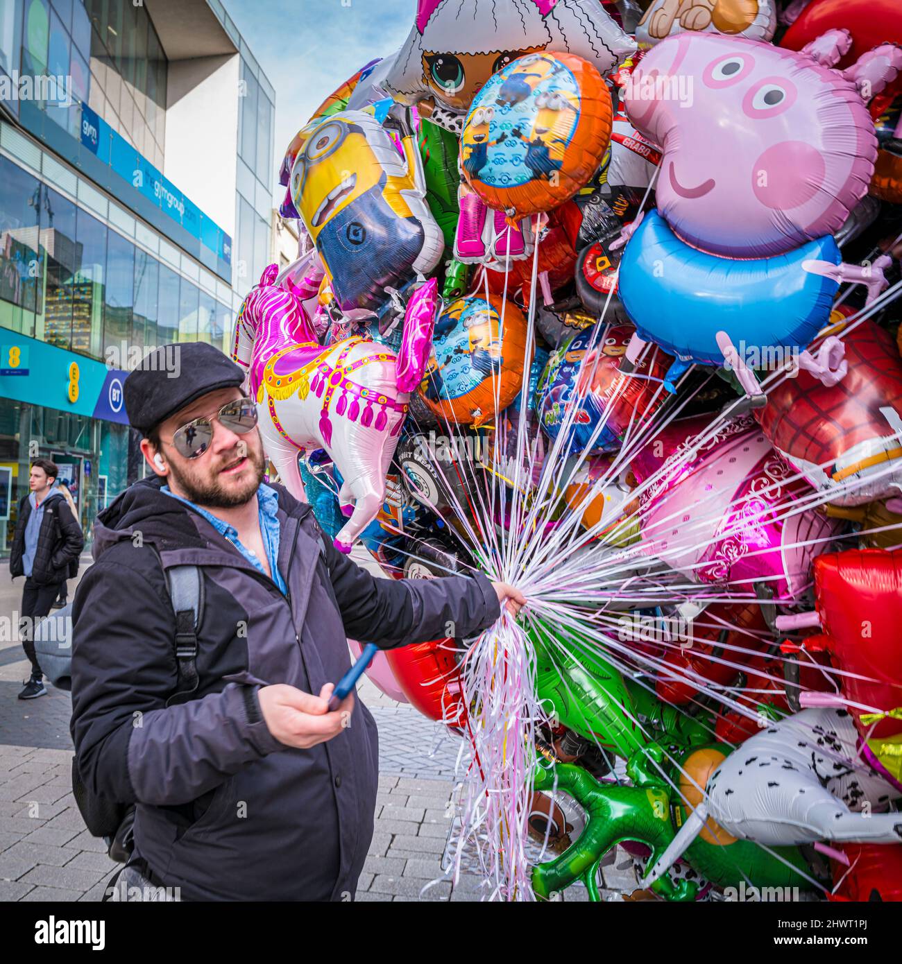 Un venditore di palloncini in una strada della città. Foto Stock