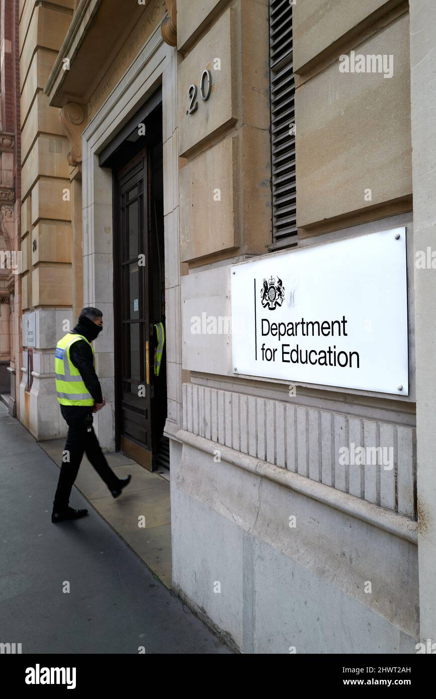 Una guardia di sicurezza presso l'edificio del Dipartimento per l'istruzione del governo britannico (DFE), Londra, Inghilterra. Foto Stock