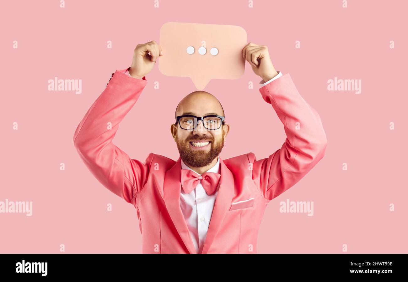 Uomo divertente positivo con simbolo di comunicazione sociale in mani isolate su sfondo rosa pastello. Foto Stock
