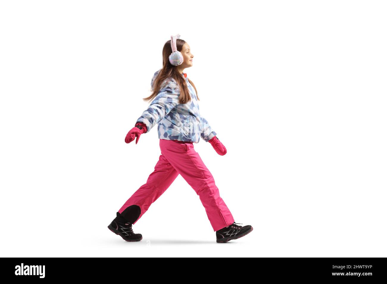 Scatto a profilo completo di una ragazza che indossa giacca invernale e pantaloni e camminare isolato su sfondo bianco Foto Stock