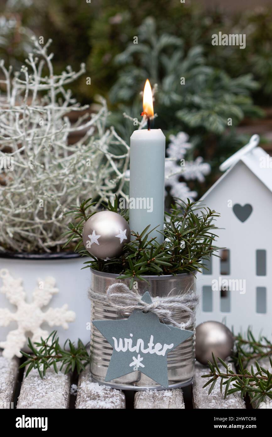 decorazione invernale con candela in stagno, natale e piante invernali Foto Stock