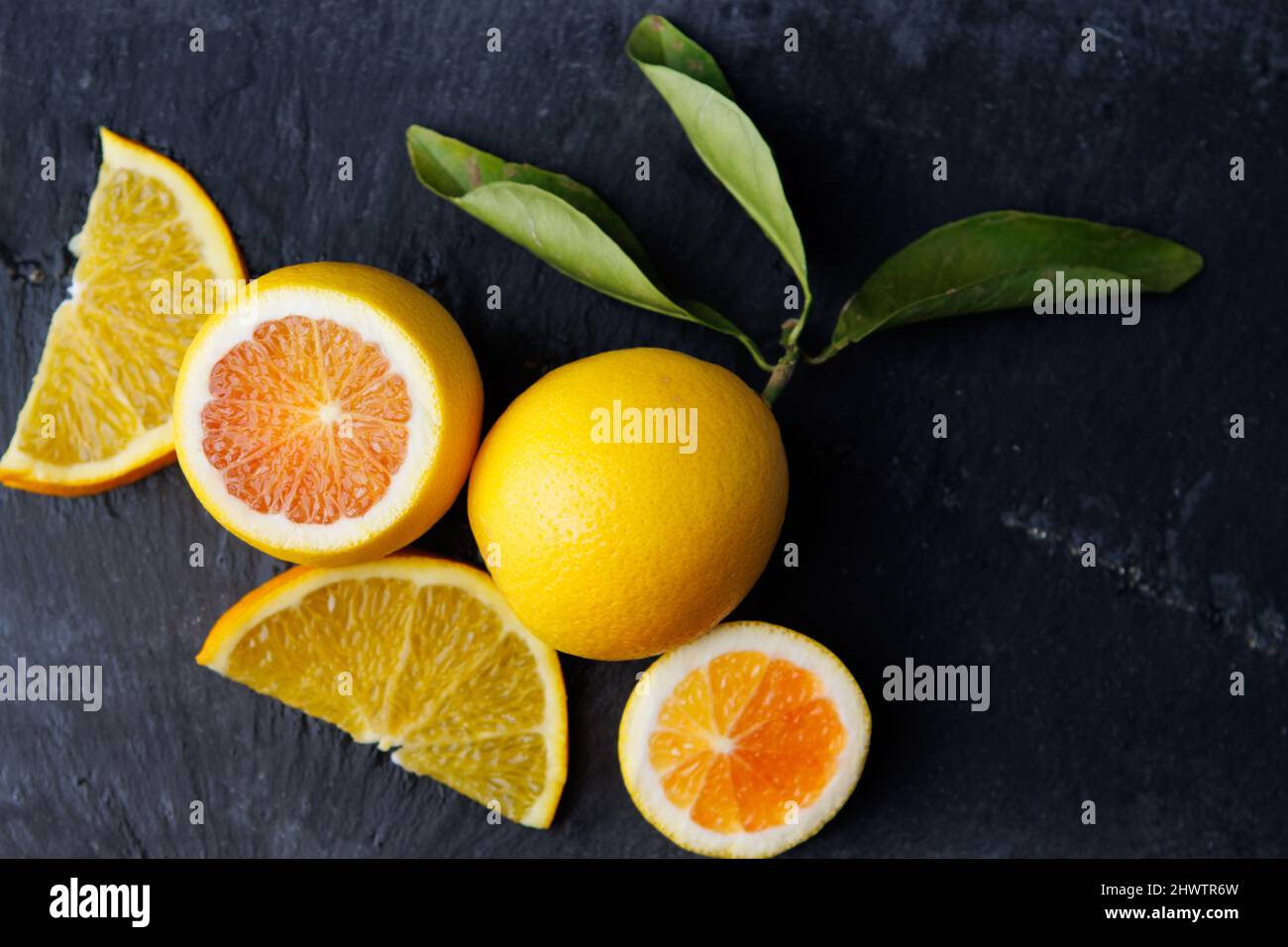 arancio di sangue e fette di arancio su sfondo scuro Foto Stock