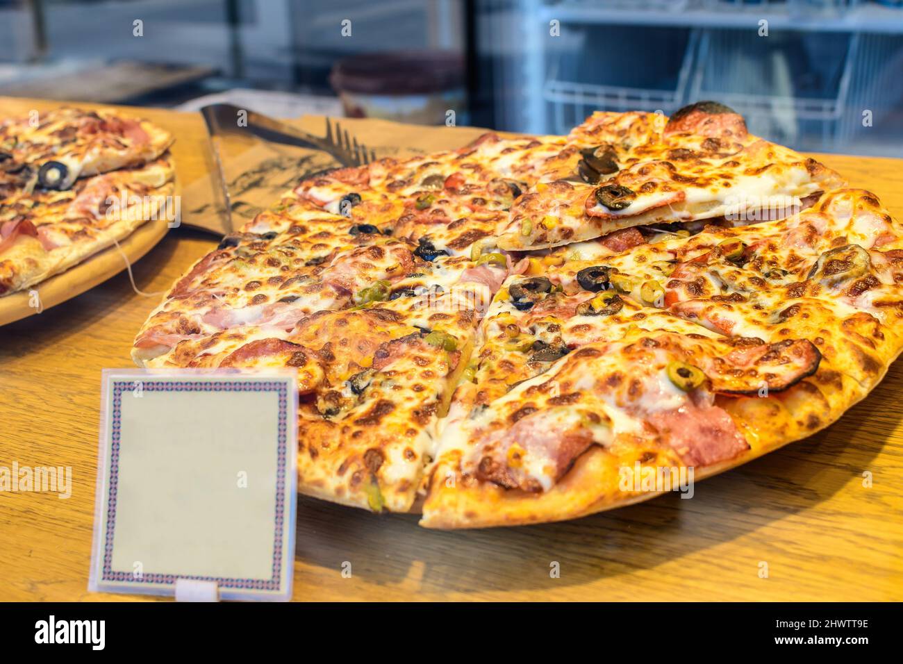 Pizza italiana tradizionale con prosciutto, formaggio mzozarella e olive in vendita presso un festival del mercato alimentare di strada a Bucarest, Romania, hea Foto Stock