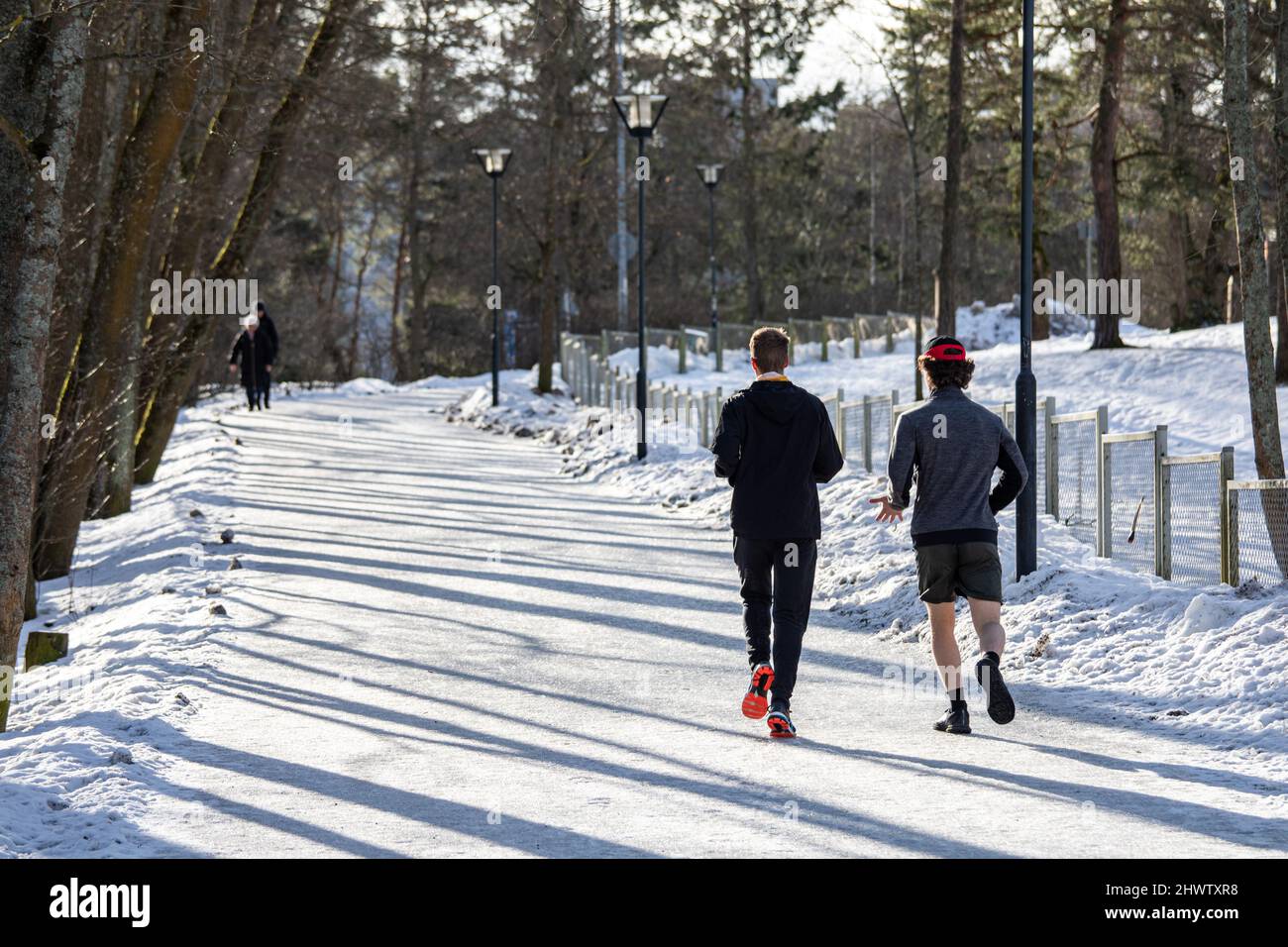 Joggers in esecuzione in una giornata invernale soleggiata a Helsinki, Finlandia Foto Stock