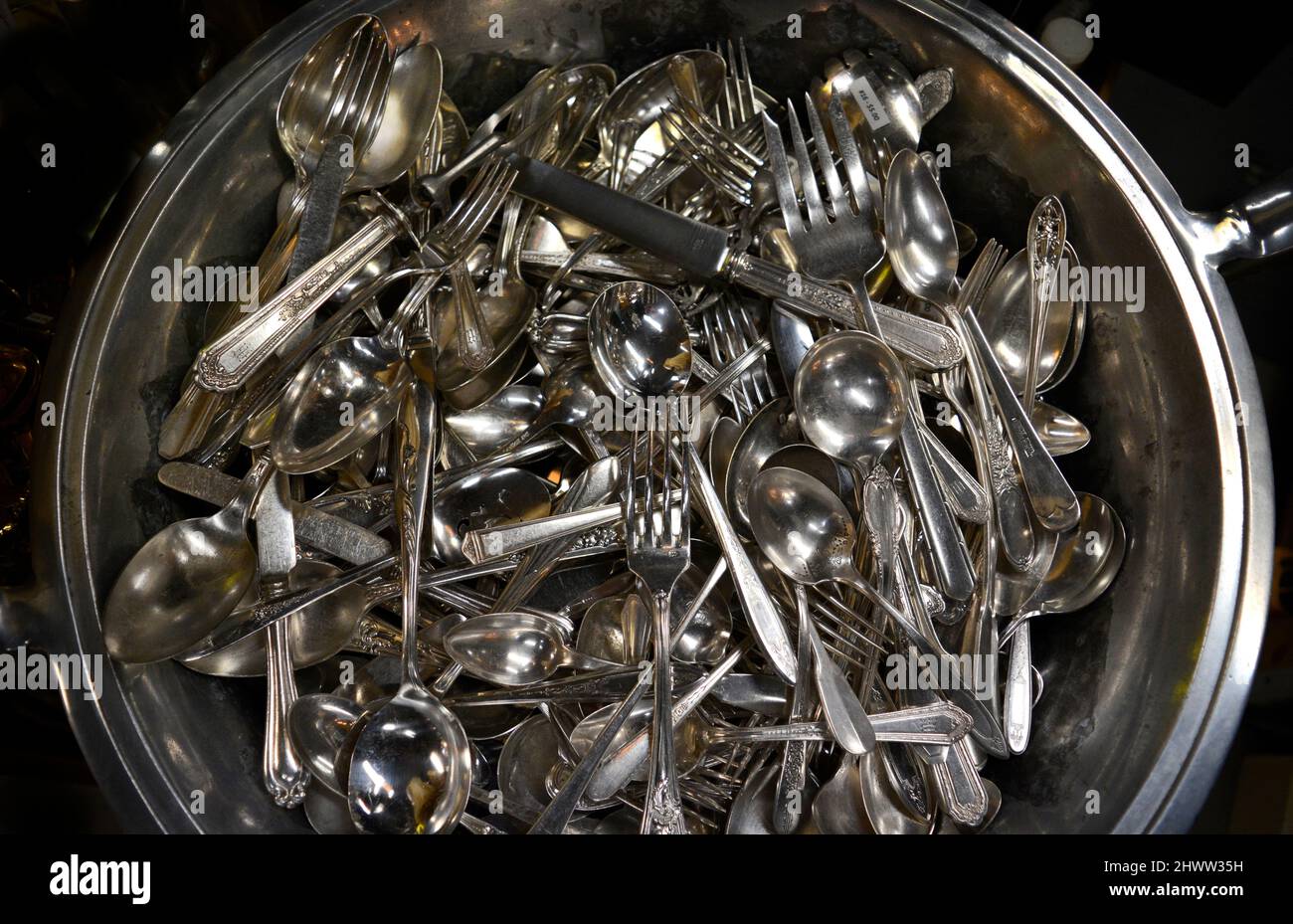 Una selezione di argenteria d'epoca, tra cui cucchiai, forchette e coltelli, in vendita in un negozio di antiquariato. Foto Stock