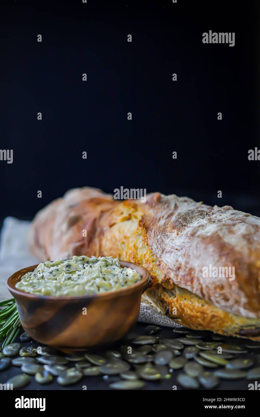 Pane fatto in casa con semi di zucca e burro di rosmarino Foto Stock