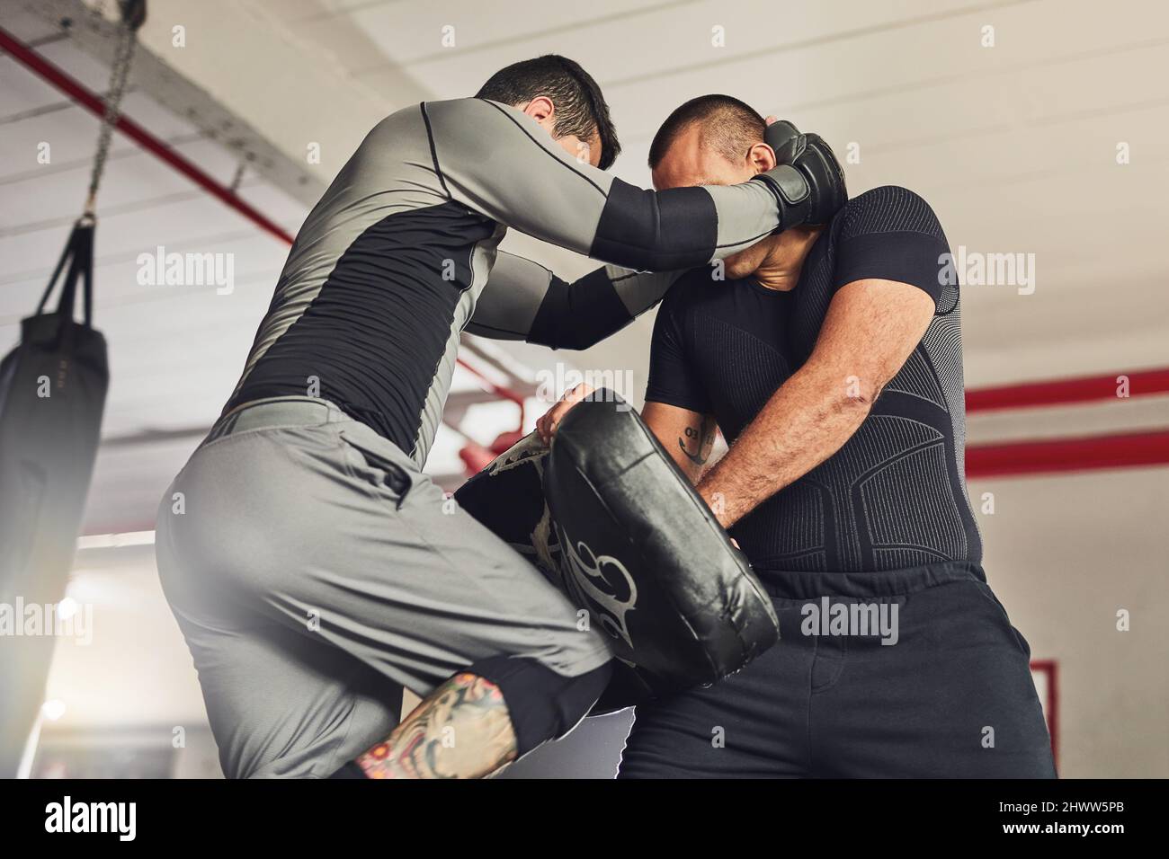 Lavorando al suo gioco gambe. Scatto corto di due combattenti professionisti che sparano in palestra. Foto Stock