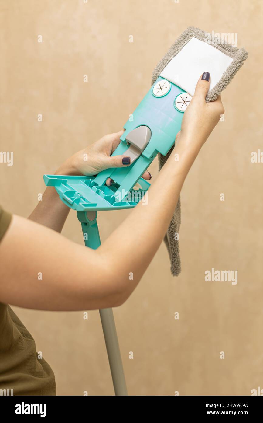 donna che mette su una testa mop per la pulizia Foto Stock