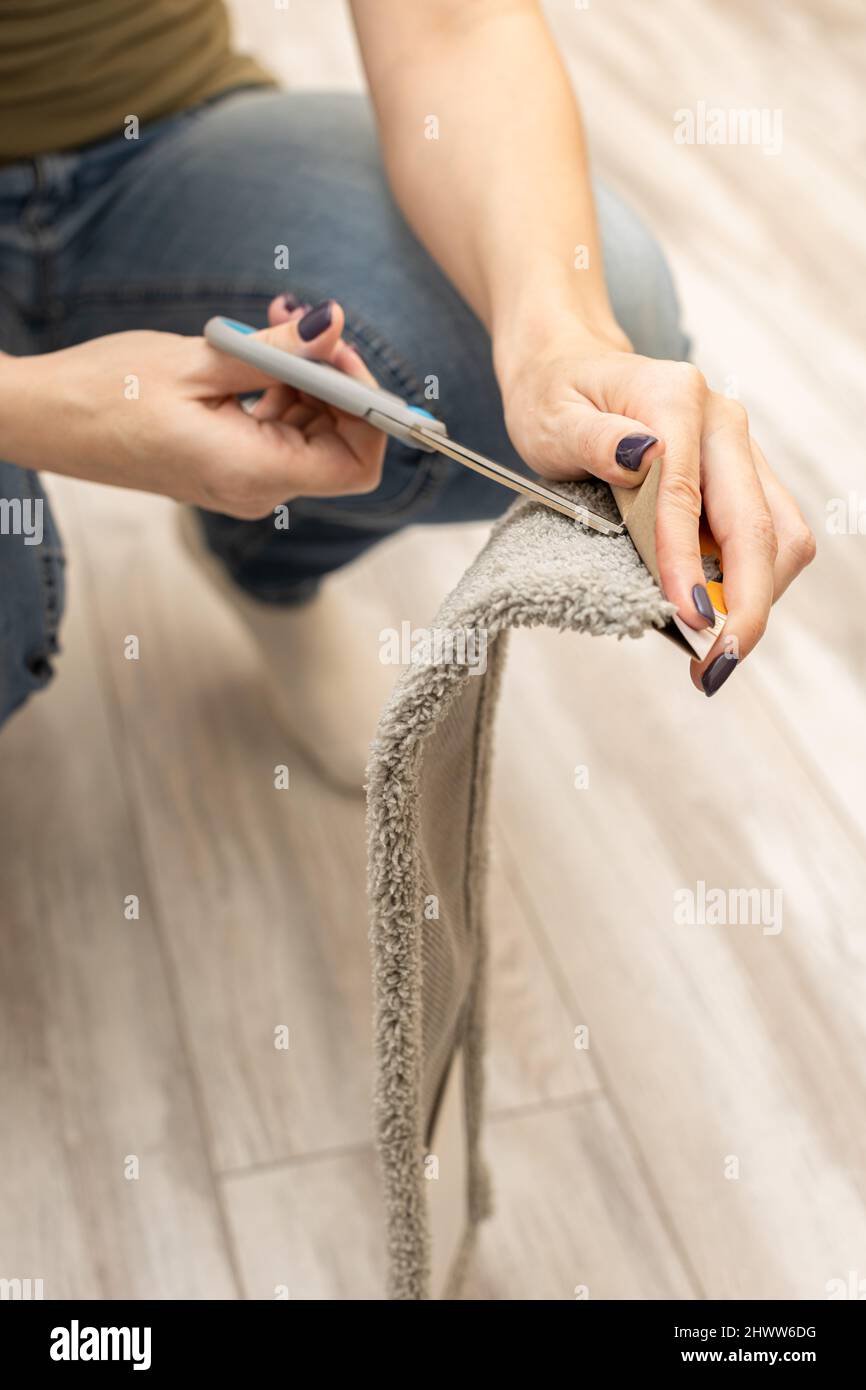una donna taglia un'etichetta con le forbici Foto Stock