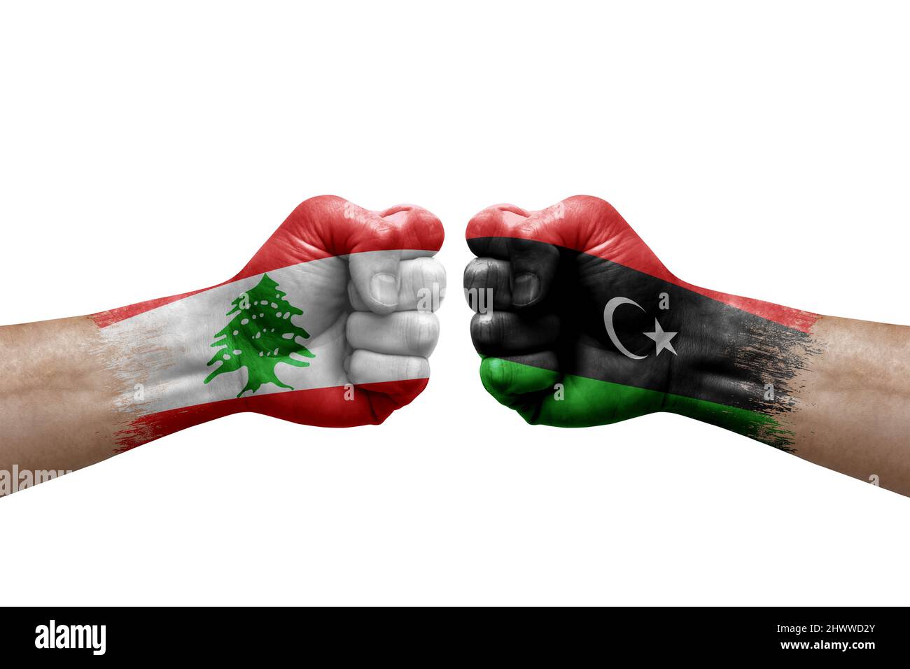 Due mani si pugno l'una all'altra su sfondo bianco. Le bandiere di paese dipinse i pugni, concetto di crisi di conflitto tra libano e libia Foto Stock