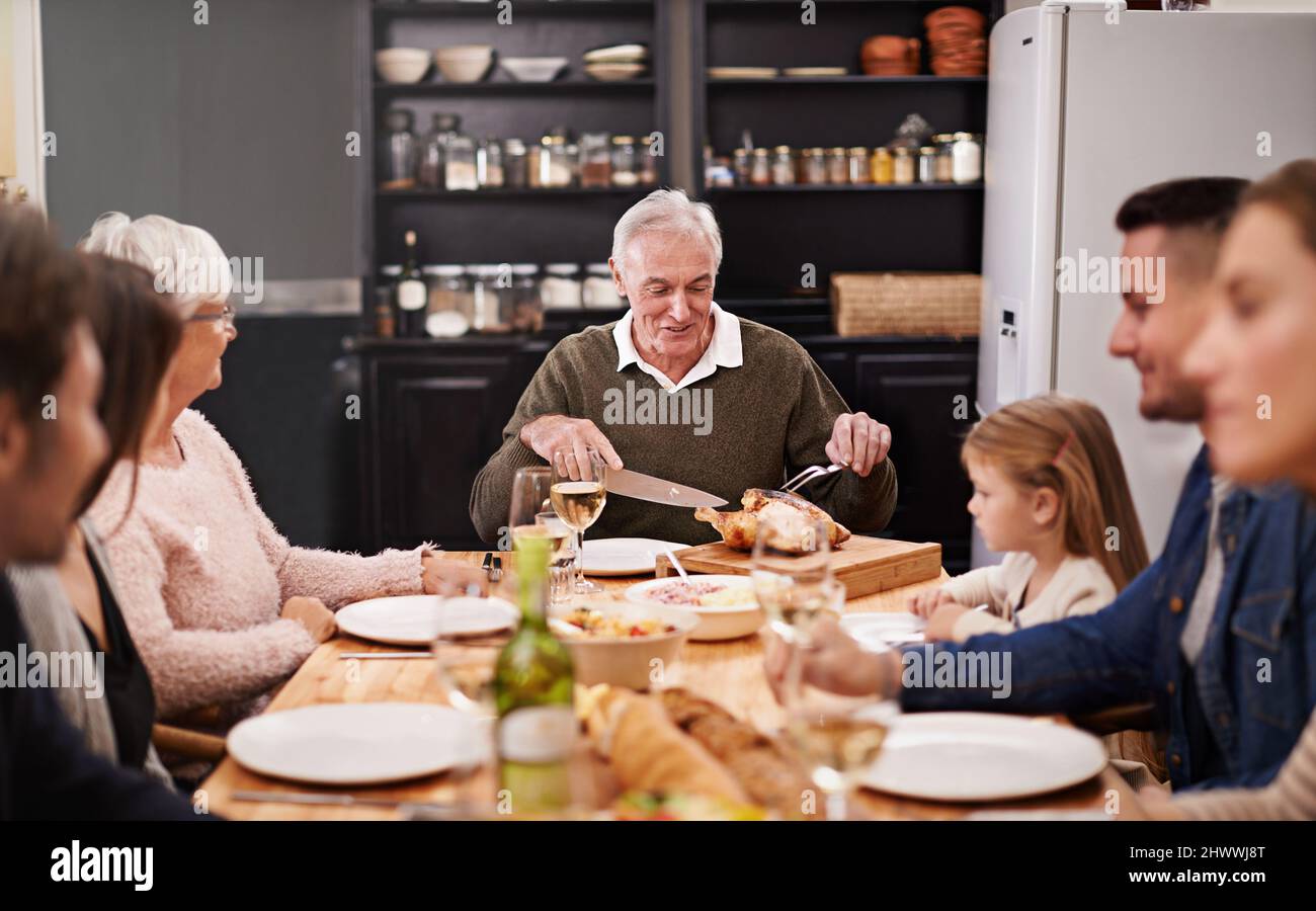 Si riuniscono sempre in occasioni speciali. Scatto corto di una famiglia seduta giù a cena. Foto Stock