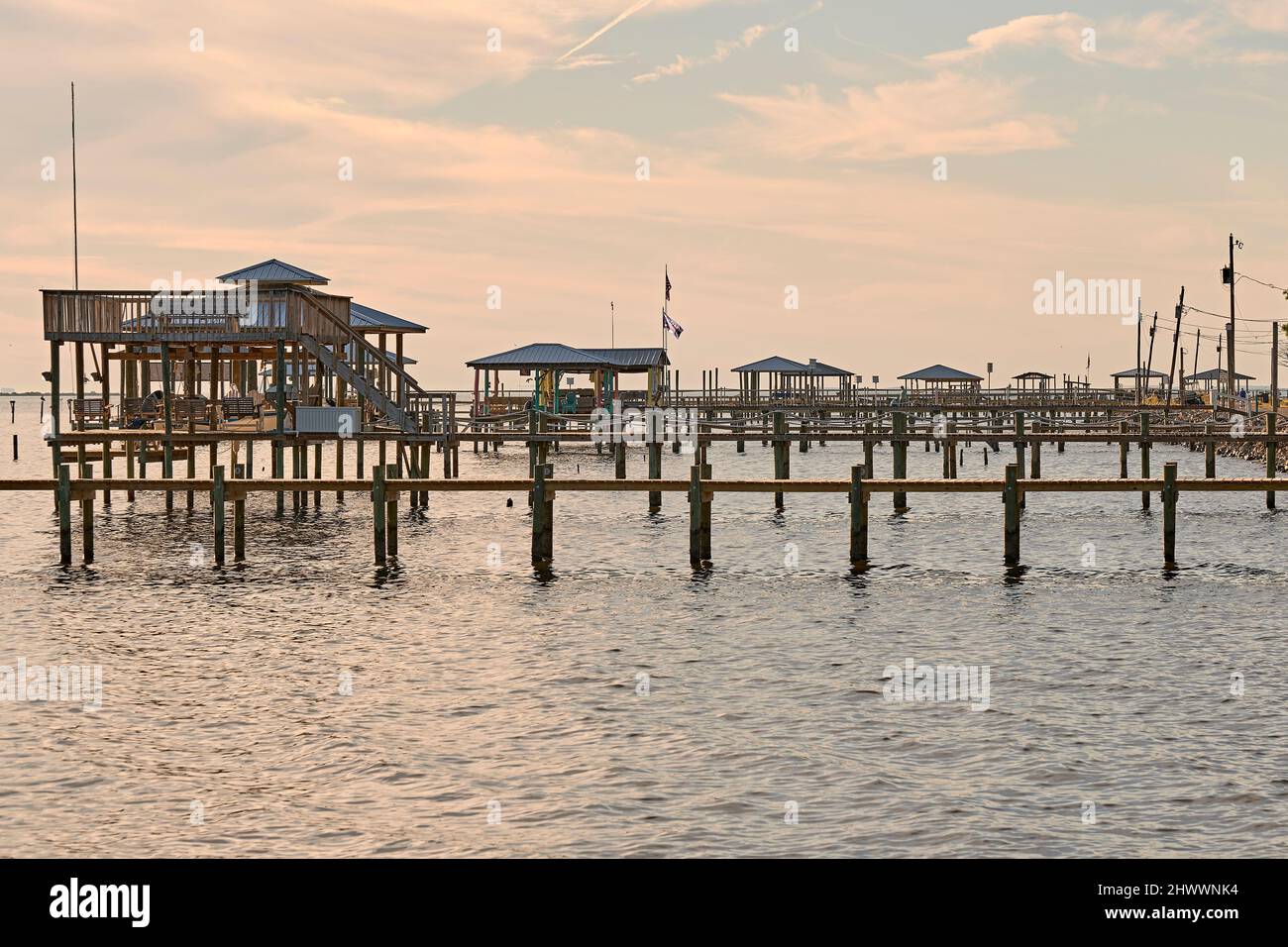 Banchine di legno, moli, case di barche e pali lungo la riva di Mobile Bay sulla costa del Golfo, vicino a Coden Alabama, USA. Foto Stock