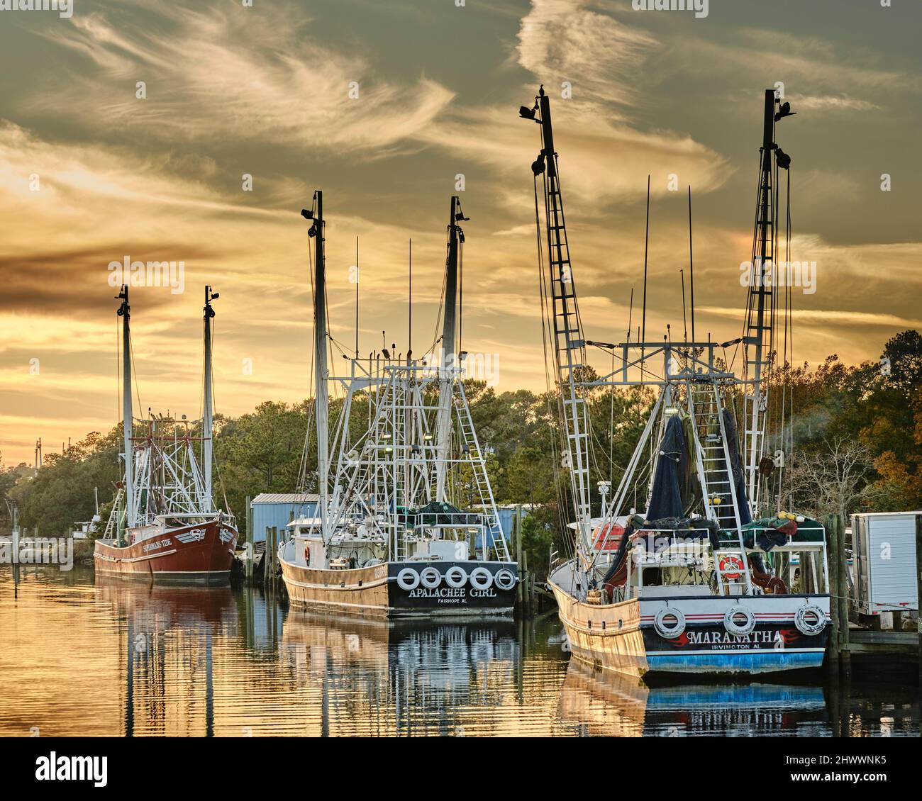 La pesca commerciale di imbarcazioni e natanti adibiti alla pesca di gamberetti legato fino al tramonto in Bayou La Batre Alabama, Stati Uniti d'America. Foto Stock