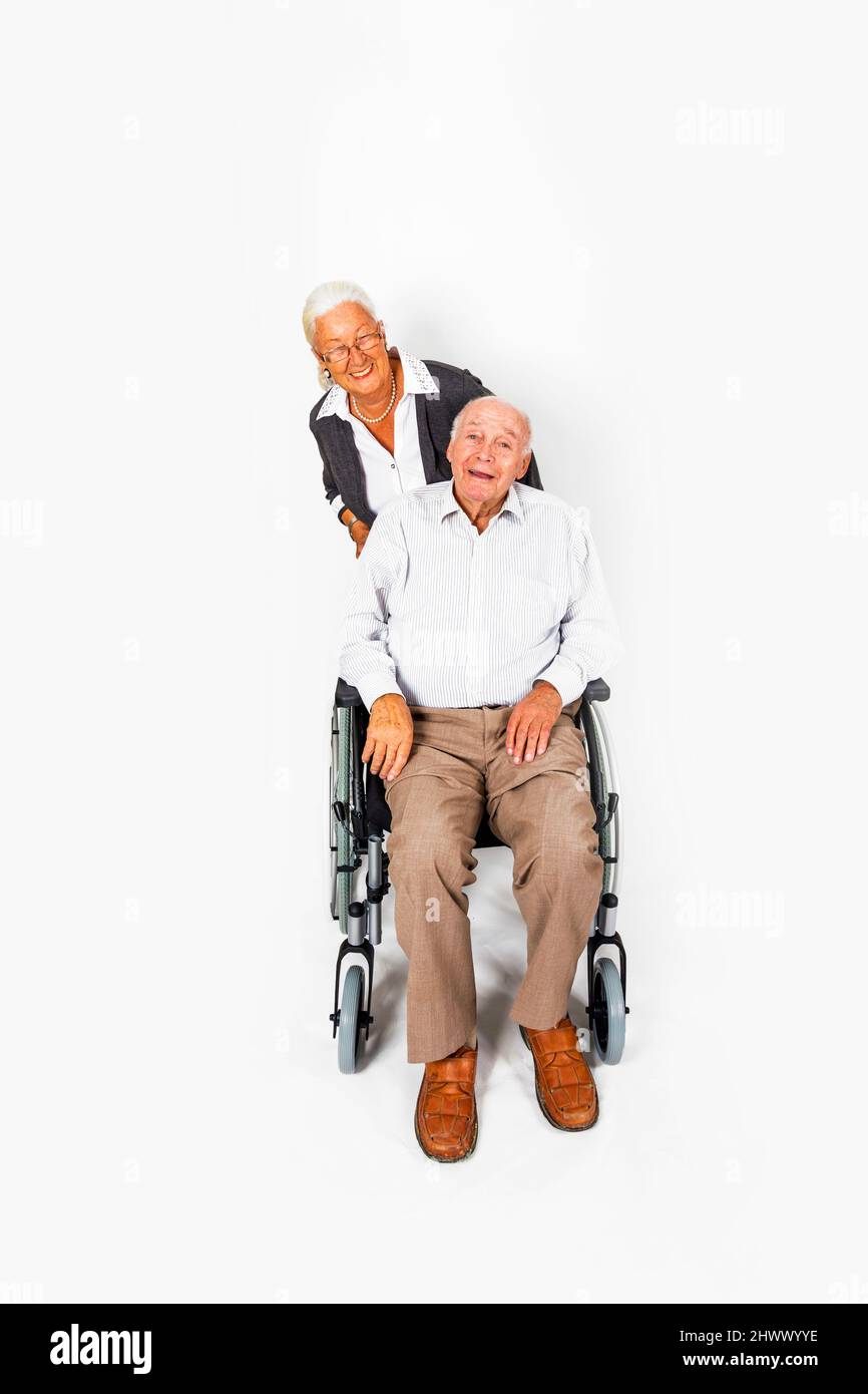 Felice coppia senior con uomo in sedia a rotelle Foto Stock