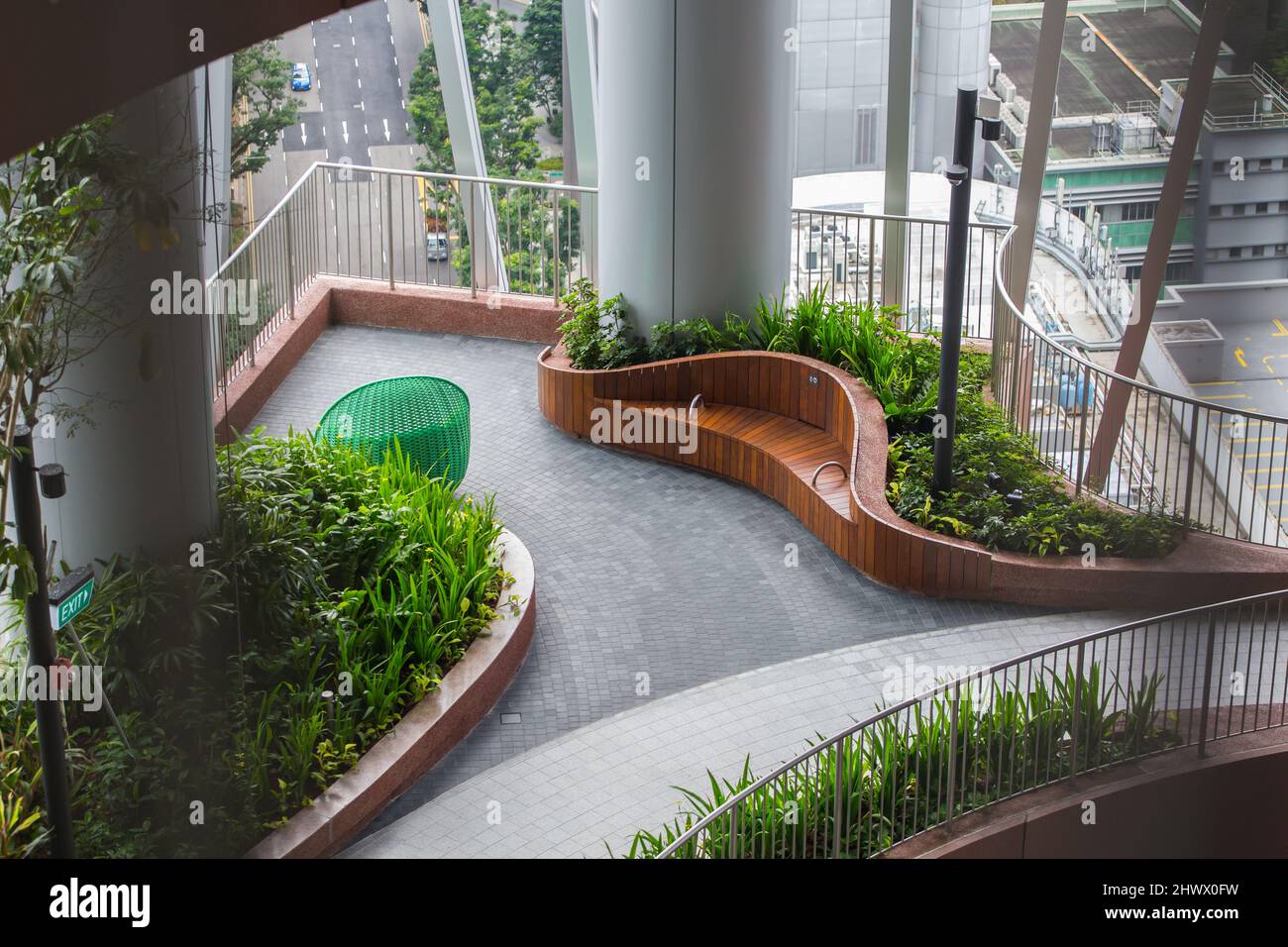 Uno spazio aperto per il pubblico dove riposare le gambe stanche all'Oasi Verde di CapitaSpring, alberi e piante piantati all'interno dell'edificio. Singapore. Foto Stock