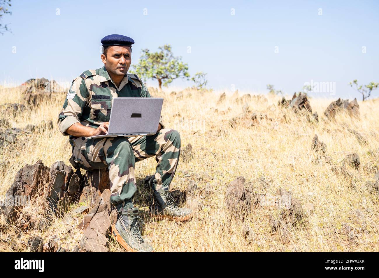 Addetto ai servizi che utilizza il computer portatile in cima alla montagna per la raccolta dei dati - concetto di intelligenza, connessione a Internet, comunicazione e sorveglianza Foto Stock