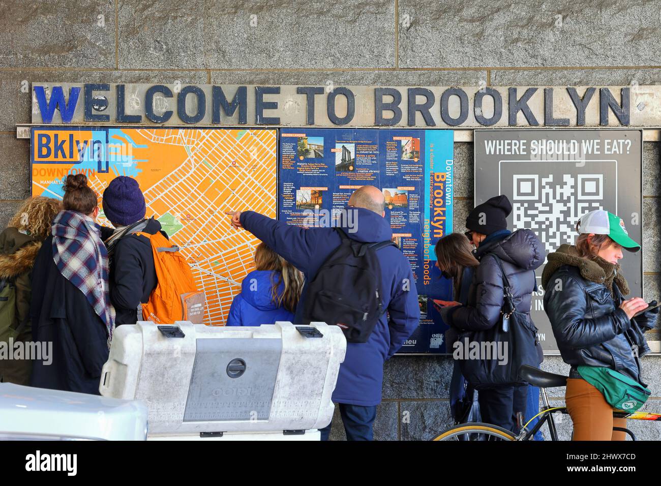Turisti che indicano una mappa di Brooklyn, New York. I turisti che guardano una mappa di Brooklyn e le persone che cercano indicazioni sul loro telefono. Foto Stock