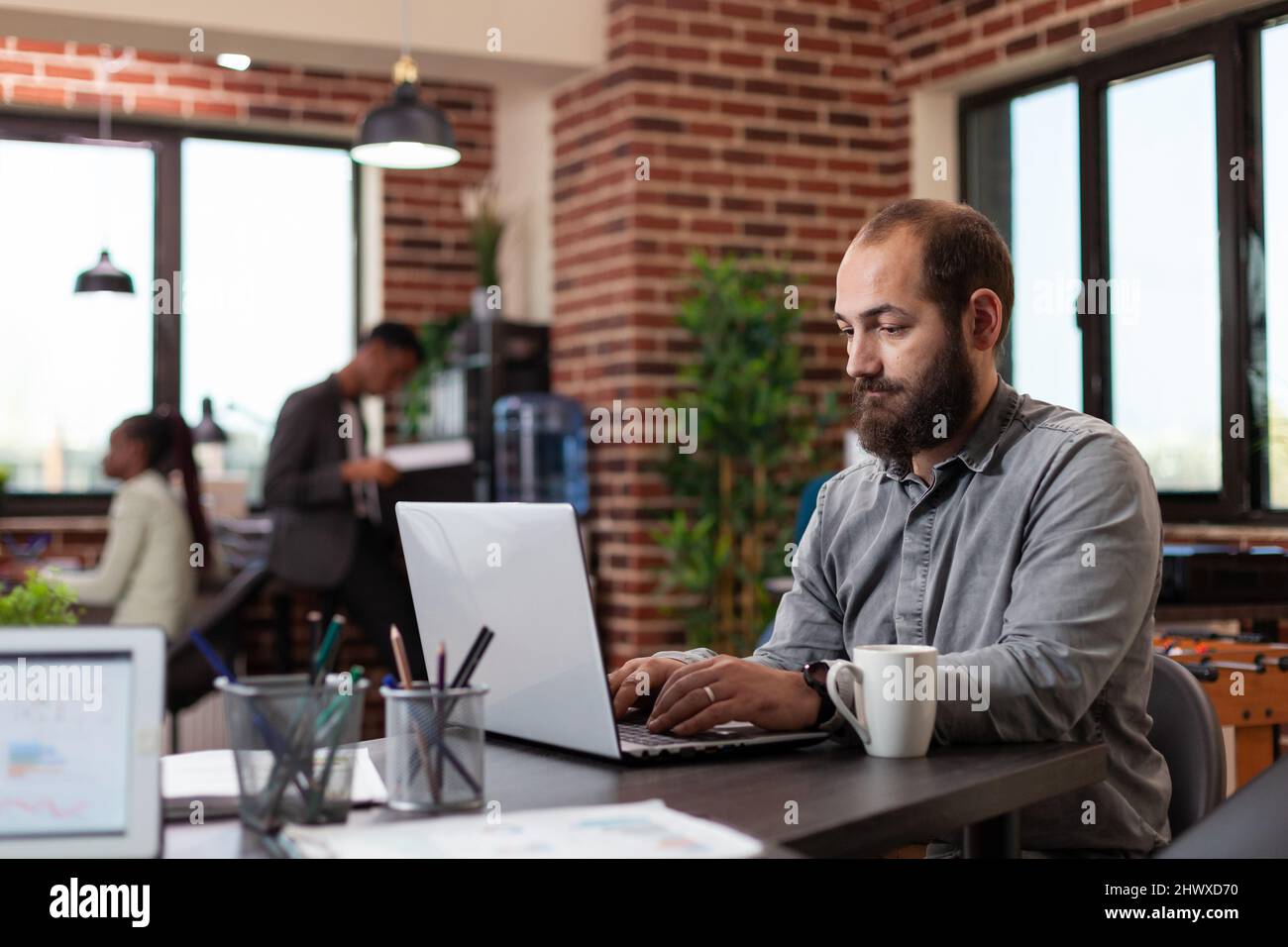 Uomo freelance che digita idee per il progetto di marketing, analizzando le statistiche aziendali utilizzando un computer portatile. Uomo d'affari che lavora nella collaborazione di gestione di pianificazione di ufficio di startup Foto Stock