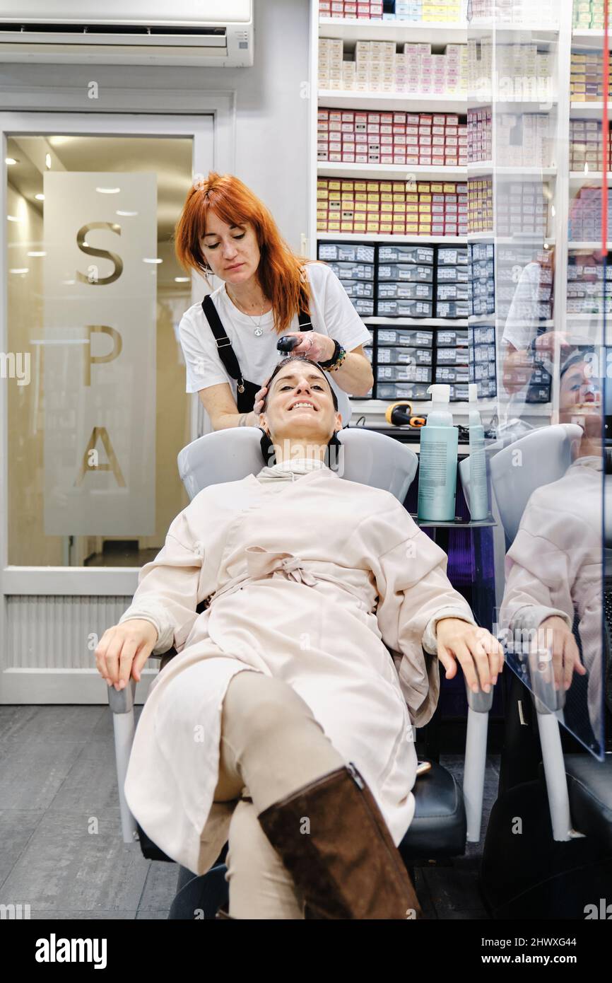 Parrucchiere lavaggio dei capelli di una donna cliente nel salone di bellezza. Foto Stock