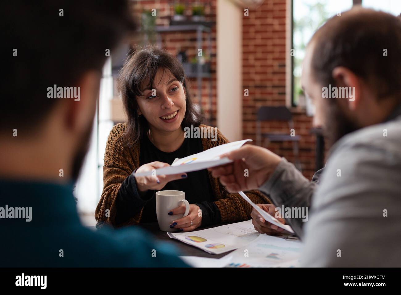 Diversi team che condividono documenti con statistiche di marketing lavorando alla pianificazione del fatturato aziendale collaborazione aziendale. Imprenditori multietnici che lavorano a progetti di brainstorming idee in startup Office Foto Stock