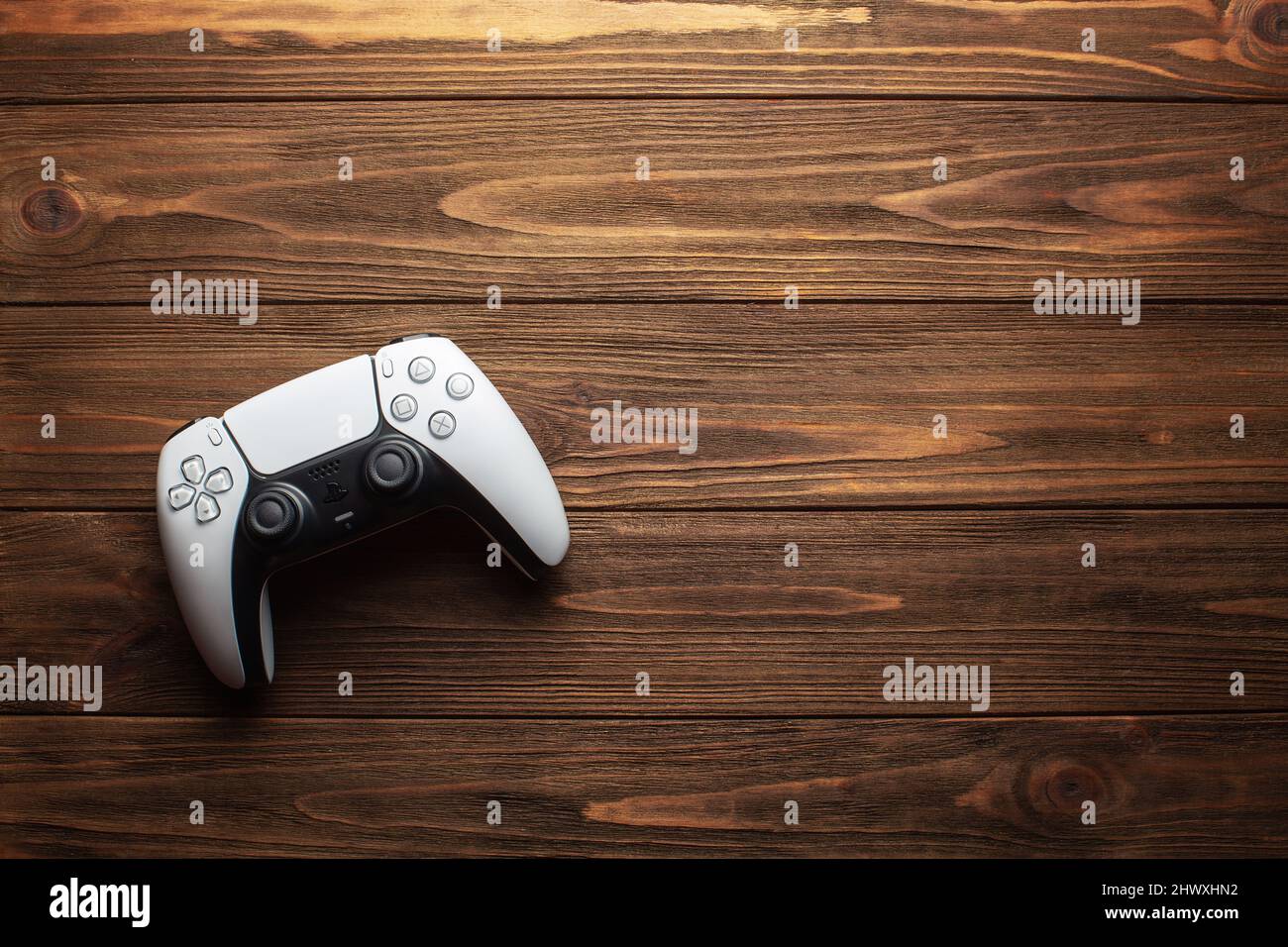 Controller Dualsense PS5 su sfondo in legno, concetto di gioco Foto Stock