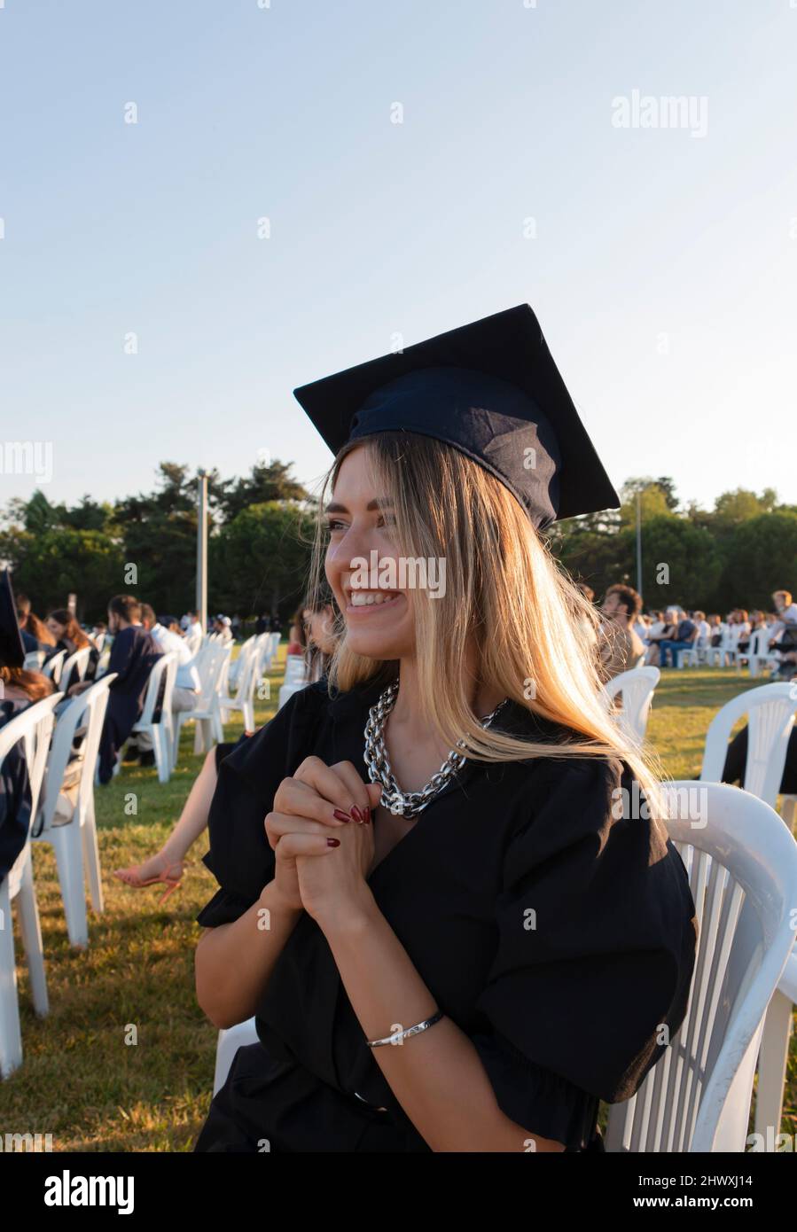 Studente laureato in piedi con tappo. La ragazza si è laureata all'università ed è così felice e orgogliosa. Laurea di primo livello. Risultati educativi. Foto Stock