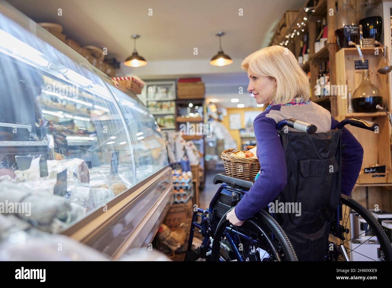 Donna in sedia a rotelle Shopping per cibo a Delicatessen Foto Stock