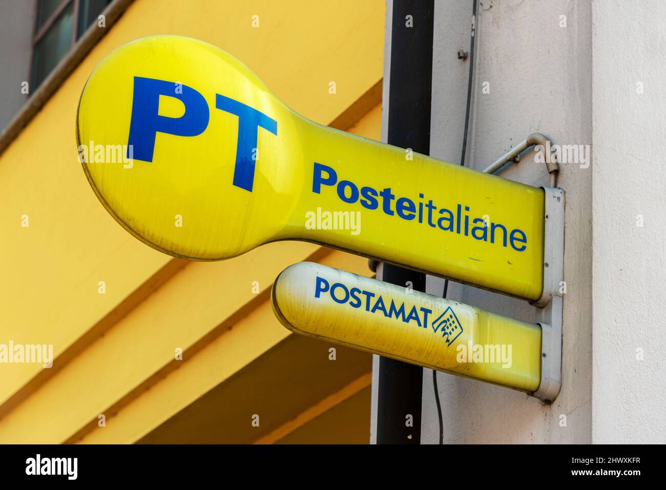 Fossano, Cuneo, Italy - 07 marzo 2022: PT Italy il logo della posta e il cartello postamat sono apparsi sul cartello giallo all'esterno dell'ufficio postale italiano Foto Stock