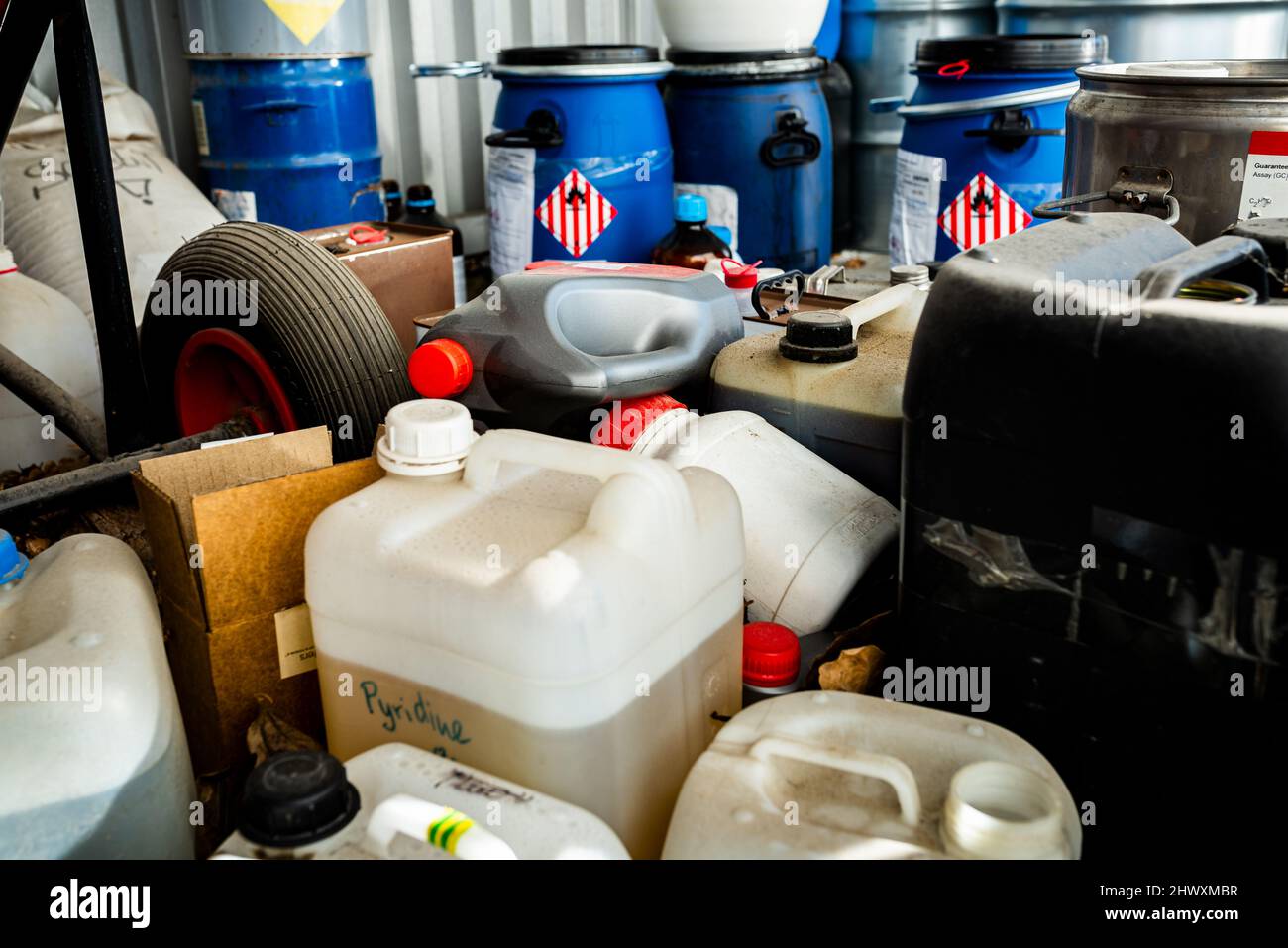 Barili in metallo e plastica contenenti sostanze chimiche pericolose dell'industria, concetto di gestione dei rifiuti Foto Stock