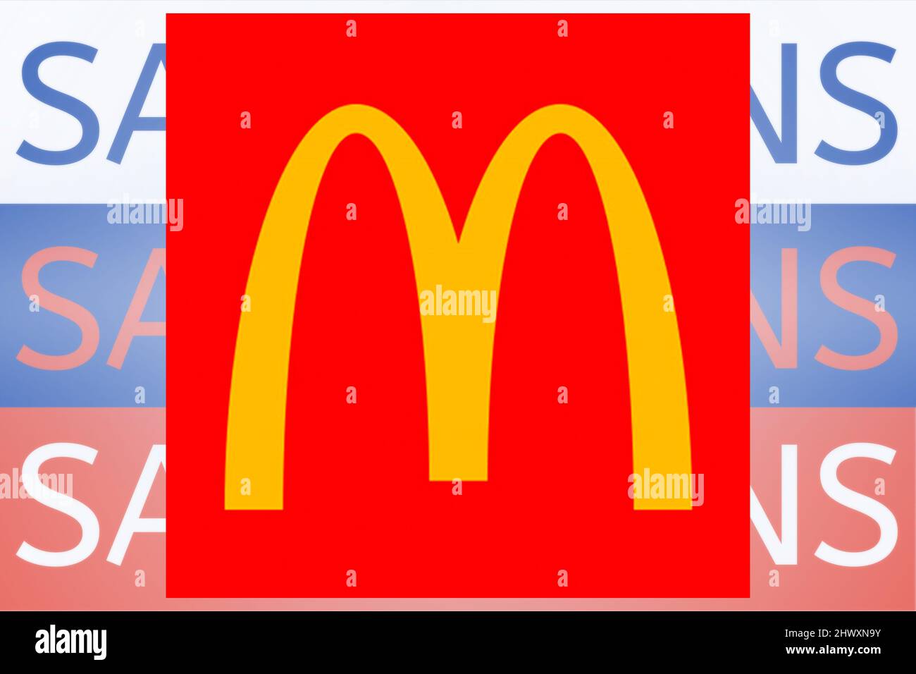 Logo McDonalds davanti al testo della sanzione sulla bandiera russa. Nuove sanzioni contro la Russia per l'invasione dell'Ucraina. Foto Stock