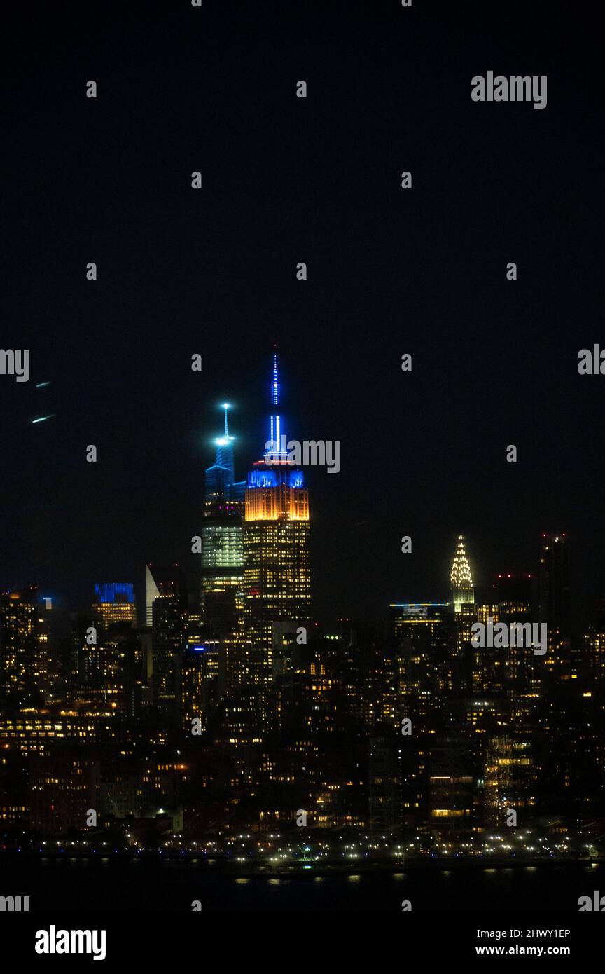 Skyline di New York con luci blu e gialle, in solidarietà con l'Ucraina Foto Stock
