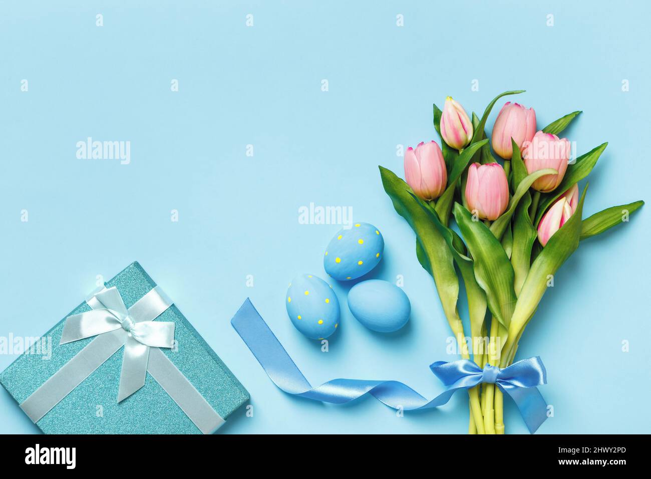 Cartolina uova di Pasqua regalo bouquet tulipani su sfondo blu con spazio copia. Foto Stock