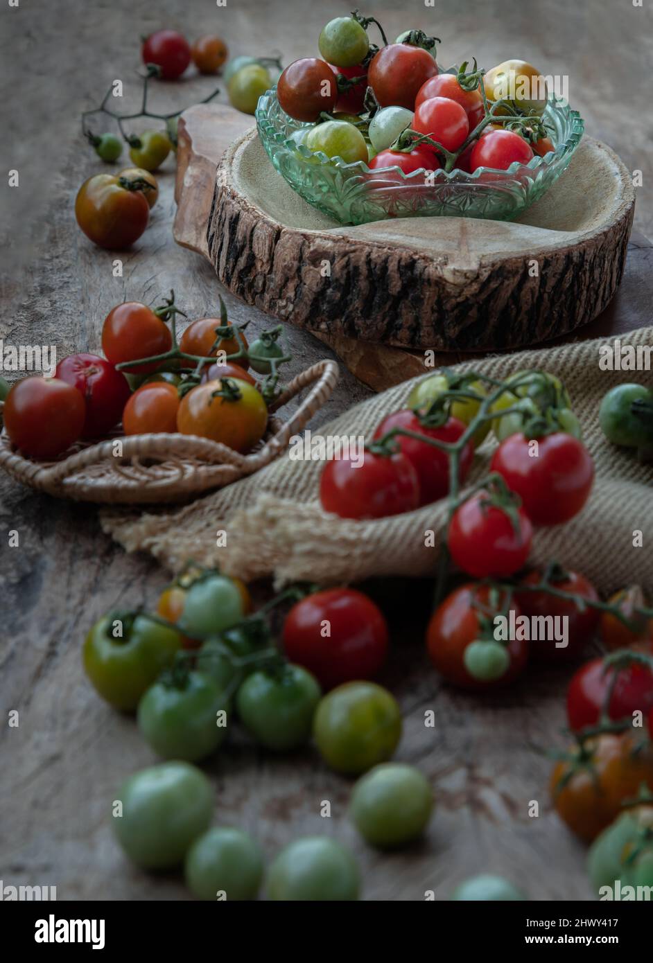 Gruppo di variegata varietà di pomodori freschi (Mini Cherry Tomatos) su vecchio sfondo di legno tavola. Messa a fuoco selettiva. Foto Stock