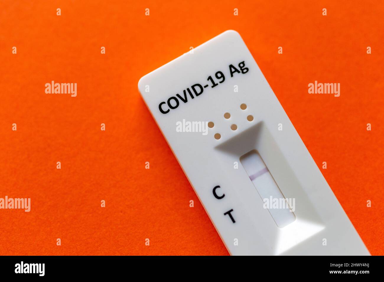 Risultato negativo del test utilizzando un dispositivo di test rapido per COVID-19 su sfondo arancione. Foto Stock