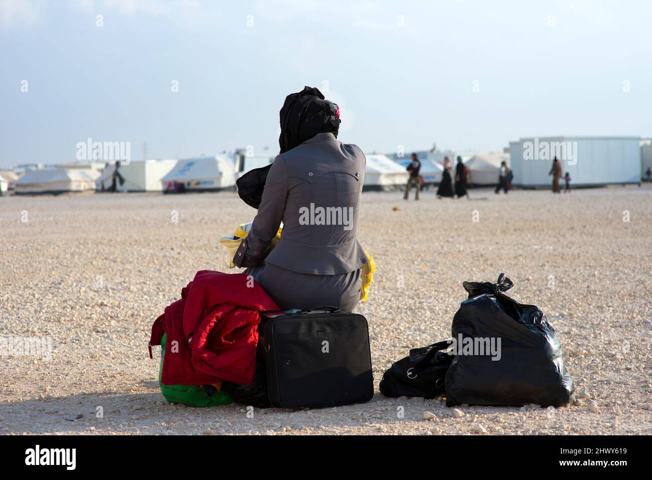 Al Za'atari, al Mafraq, Giordania. Rifugiato femminile di guerra siriana seduto sul suo bagaglio e valigie prima di entrare / lasciare il campo profughi UNHC. Foto Stock