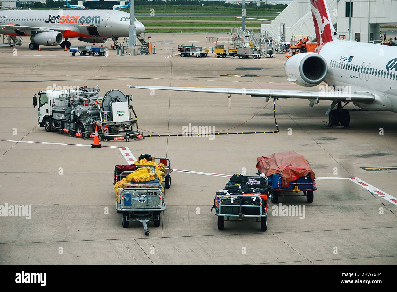 i movimentatori di bagagli aeroportuali caricano bagagli e merci sul jet passeggeri Foto Stock